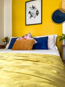 a bedroom with a bed with a yellow wall at Suíte com Banheira, próximo à Praia Litorânea Limão Siciliano Limoneto House Eventos, Hostel e Pousada in São Luís