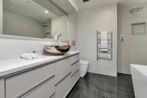 uma casa de banho branca com um lavatório e um WC em Penthouse Premier em Auckland