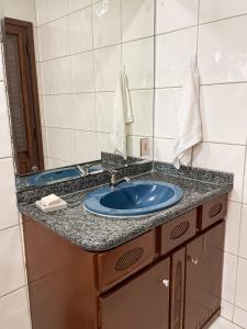 a bathroom with a blue sink and a mirror at Suíte com Banheira, próximo à Praia Litorânea Limão Siciliano Limoneto House Eventos, Hostel e Pousada in São Luís