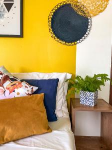 a bedroom with a yellow wall and a bed with pillows at Suíte com Banheira, próximo à Praia Litorânea Limão Siciliano Limoneto House Eventos, Hostel e Pousada in São Luís