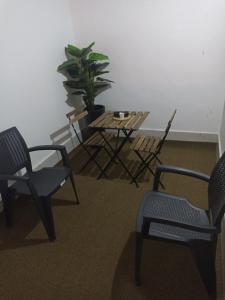 Habitación con 2 sillas, mesa y planta en MJI GROUP en Tan-Tan