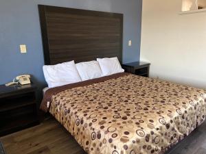 a bedroom with a bed with a large headboard at Economy Inn Fresno in Fresno
