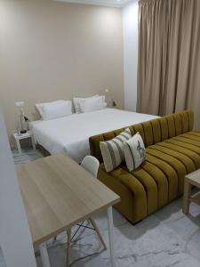 ein Schlafzimmer mit einem großen Bett und einem gelben Sofa in der Unterkunft MJI GROUP in Tan-Tan