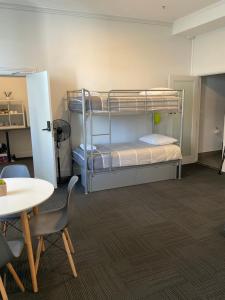 Zimmer mit einem Etagenbett, einem Tisch und Stühlen in der Unterkunft Argyle Accommodation in Hobart