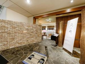 a lobby with a brick wall and a table at Tabist Abashiri Central Hotel in Abashiri