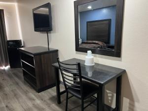 a room with a table with a chair and a mirror at Economy Inn Fresno in Fresno