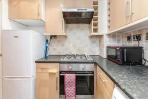 a kitchen with a stove top oven next to a microwave at APlaceToStay Central London Apartment, Zone 1 in London