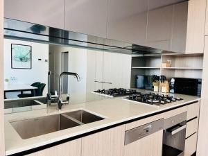 a large kitchen with a sink and a stove at Luxury 2Beds Condo with stunning city View (Parking, Gym) in Sydney