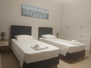 Dos camas en una habitación de hotel con toallas encima. en Ismene Apartments, en Argostoli