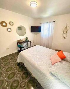 Schlafzimmer mit einem Bett mit orangefarbenem Kissen in der Unterkunft 2C - Couples Getaway-5 min to Crashboat Beach in Aguadilla