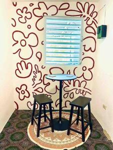a table and two stools in front of a wall at 2C - Couples Getaway-5 min to Crashboat Beach in Aguadilla