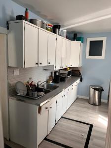 una cocina con armarios blancos y fregadero en Guest House, en Winnipeg