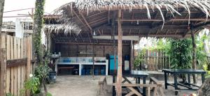 - un bâtiment avec une table et un toit de chaume dans l'établissement Dream Catcher Nipas Siargao, à General Luna