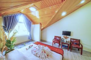 - une chambre avec un grand lit et un plafond en bois dans l'établissement Moc Nhien Hostel Da Lat, à Đà Lạt
