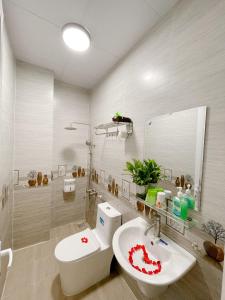Moc Nhien Hostel Da Lat في دالات: حمام مع حوض ومرحاض ومرآة