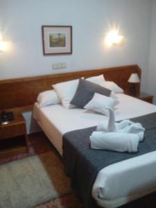 a bedroom with a bed with two towels on it at Complejo Hotelero Saga in Manzanares