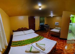 Un dormitorio con una cama y un sofá en una habitación. en Apo Pension House, en Corón