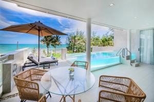 a dining room with a table and chairs and a pool at Beachfront Residences - Stunning Sea and Lake View in Bang Tao Beach