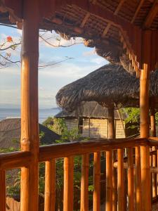 a view from the porch of a resort with a straw roof at RUSTIQUE RUE Mabini - Hostel in Batangas City