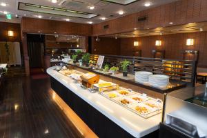 a buffet line with plates of food in a restaurant at Garden Hotel Kanazawa in Kanazawa