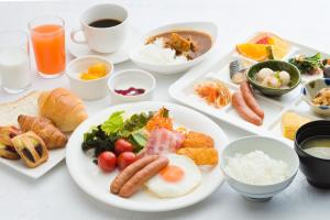 una mesa blanca cubierta con platos de comida y bebida en Garden Hotel Kanazawa, en Kanazawa