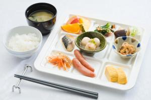 una bandeja de comida con sushi y otros alimentos. en Garden Hotel Kanazawa en Kanazawa