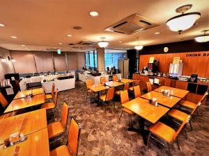 a dining room with wooden tables and chairs at Suizenji Comfort Hotel in Kumamoto