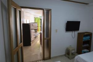 a room with a door leading to a room with a refrigerator at Apartahotel El Horizonte in Guatapé
