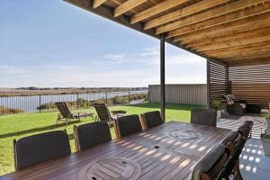 a wooden table and chairs on a patio at Big Blue Tailem Bend in Tailem Bend