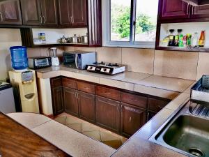 una cocina con armarios de madera y fregadero. en Den Den Guesthouse, en Basco