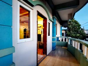 a door to a balcony of a house at Den Den Guesthouse in Basco