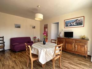 sala de estar con mesa y sofá púrpura en Appartement Cambo-les-Bains, 2 pièces, 2 personnes - FR-1-495-112, en Cambo-les-Bains