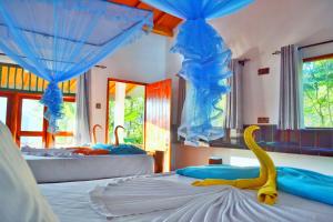 a bedroom with two beds with a yellow swan on the bed at Rainbow Sky Cottage in Ella