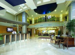 a lobby with a table and chairs in a building at Grand Cettia Hotel in Marmaris