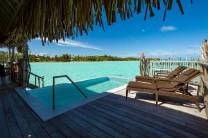 a swimming pool on a deck next to the water at InterContinental Bora Bora & Thalasso Spa, an IHG Hotel in Bora Bora