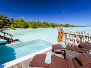 - une piscine sur une terrasse à côté d'une masse d'eau dans l'établissement InterContinental Bora Bora & Thalasso Spa, an IHG Hotel, à Bora Bora