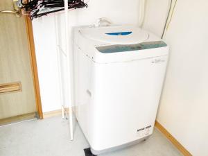 een wasmachine in een kamer met een wastafel bij AsobiBASE Yamabare-House in Ishigaki Island