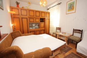a bedroom with a bed and a couch and chairs at Apartments by the sea Vis - 8885 in Vis