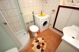 a bathroom with a toilet and a washing machine at Apartments by the sea Vis - 8885 in Vis