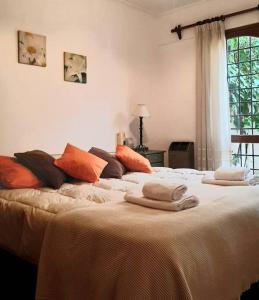 een slaapkamer met een groot bed en handdoeken bij Petit Bombal in Godoy Cruz