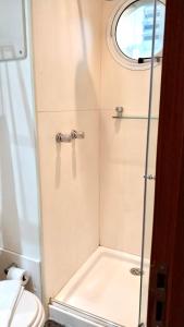 uma casa de banho com um chuveiro, um WC e uma janela. em Flat em Hotel na Bela Cintra próximo à Paulista e Consolação em São Paulo
