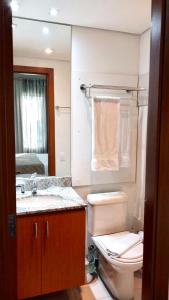 a bathroom with a toilet and a sink and a mirror at Flat em Hotel na Bela Cintra próximo à Paulista e Consolação in Sao Paulo