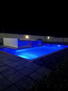 a swimming pool at night with blue illumination at Heavenly Towers in Mbazwana