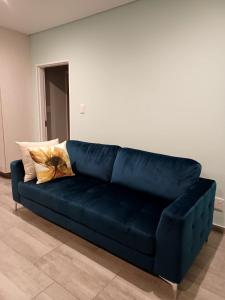 eine blaue Couch im Wohnzimmer in der Unterkunft Heavenly Towers in MʼBazwane