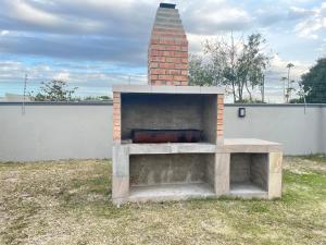 a brick fireplace in a yard next to a fence at Heavenly Towers in Mbazwana
