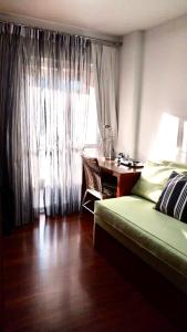 a bedroom with a bed and a desk and a window at Flat em Hotel na Bela Cintra próximo à Paulista e Consolação in Sao Paulo