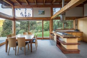 a kitchen and dining room with a table and chairs at Kaimata lodge in Dunedin