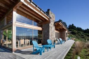 a deck with blue chairs and tables on a house at Kaimata lodge in Dunedin