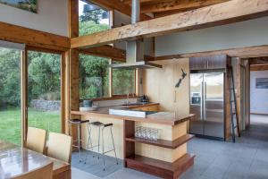 a kitchen with a counter with a refrigerator and some windows at Kaimata lodge in Dunedin