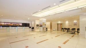 a large lobby with tables and chairs in a building at Hearton Hotel Higashi-Shinagawa in Tokyo